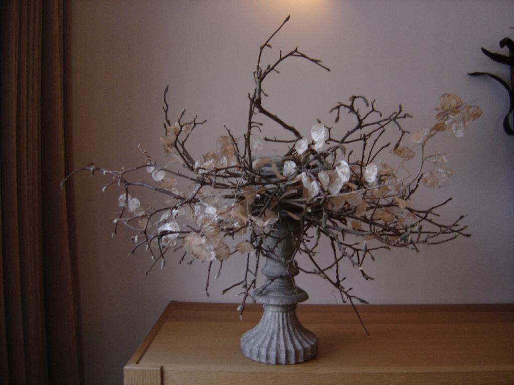 <u>Materiaal</u> <br/ > binddraad<br /> kandelaar<br /> judaspenning<br /> magnoliatakken <br /><br /><br /><u>Techniek</u><br /> takken met binddraad bevestigen aan kandelaar, judaspenning ertussen steken